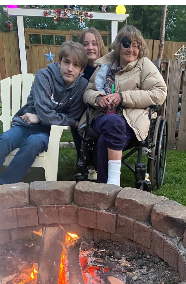 Family gathered around a backyard fire pit