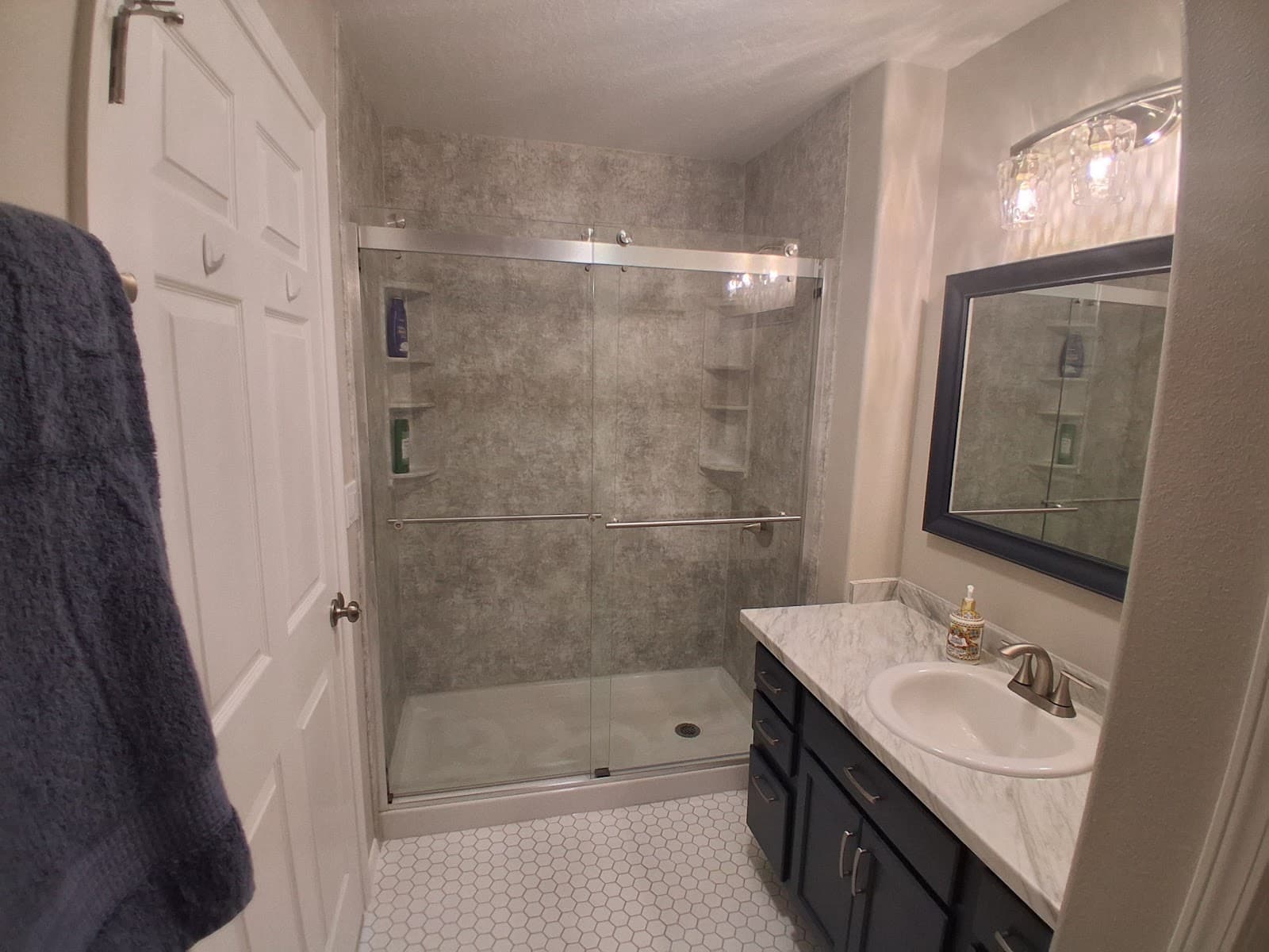 Completed Kingdom Vision Builders bathroom with gray shower and dark vanity
